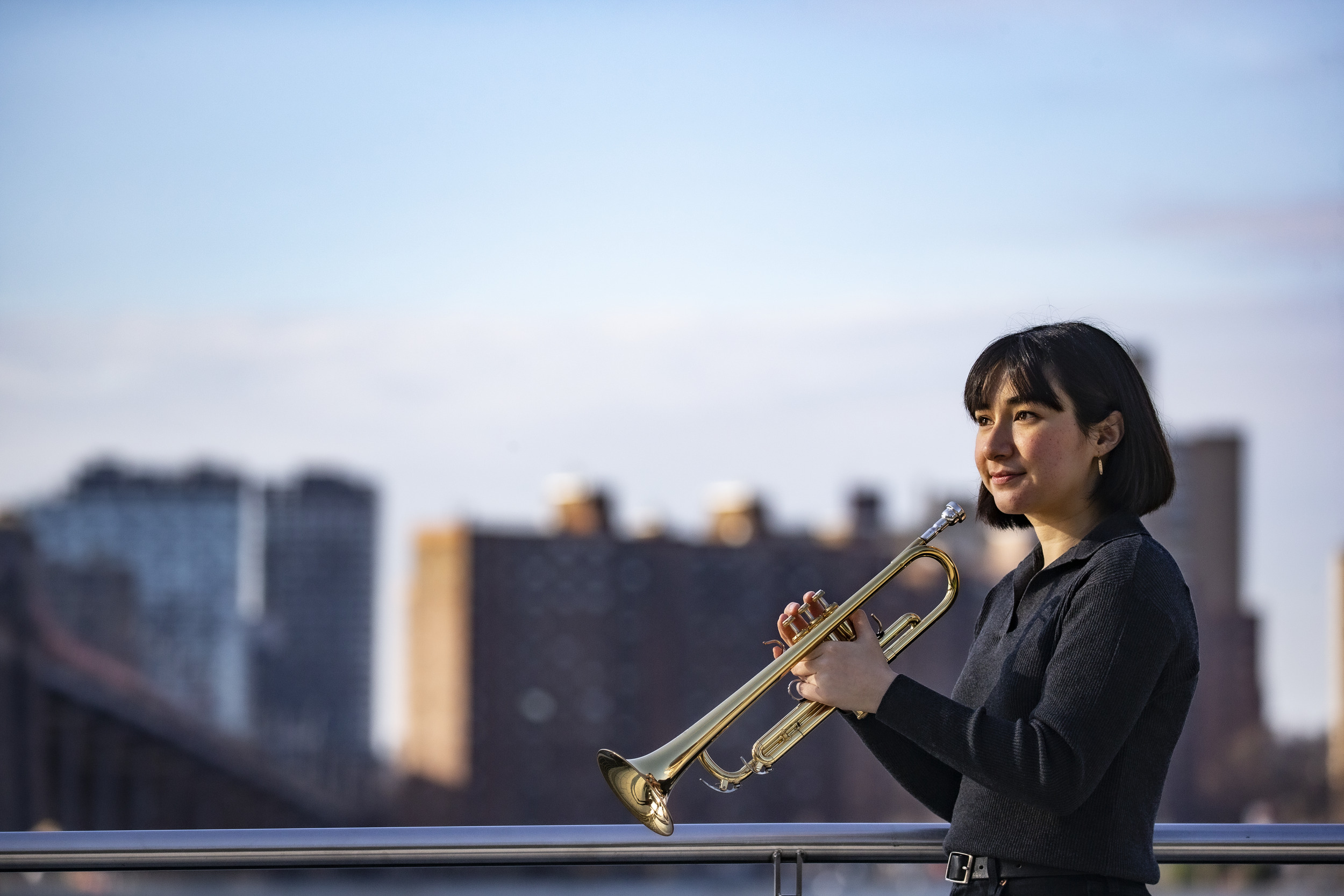 Honoree Bell Thompson with her trumpet and the New York City skyline behind her