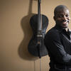Ajibola Rivers standing in front of his cello.
