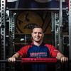 Honoree Nick LaRue smiling and posing with gym equipment