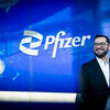 30 Under 30 honoree Nick Rivera smiling and standing in front of the Pfizer signage at his workplace