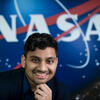 Bhautik Amin smiles in front of the NASA logo. 