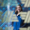 Angelina Neely stands behind glass with ALDI logos.