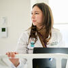 30 Under 30 honoree Ivana Kohut standing at a hospital bed and wearing a white lab coat
