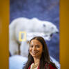 Amanda Petty poses in front of a National Geographic magazine cover..