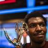 Tyji Mats holding an Emmy Award.