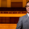Trevor Tran smiles in a theater.