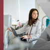 30 Under 30 honoree Ivana Kohut wearing a lab coat and standing at a computer