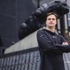 Joseph Glennon Jr. poses in front of the Carolina Panthers' statue.